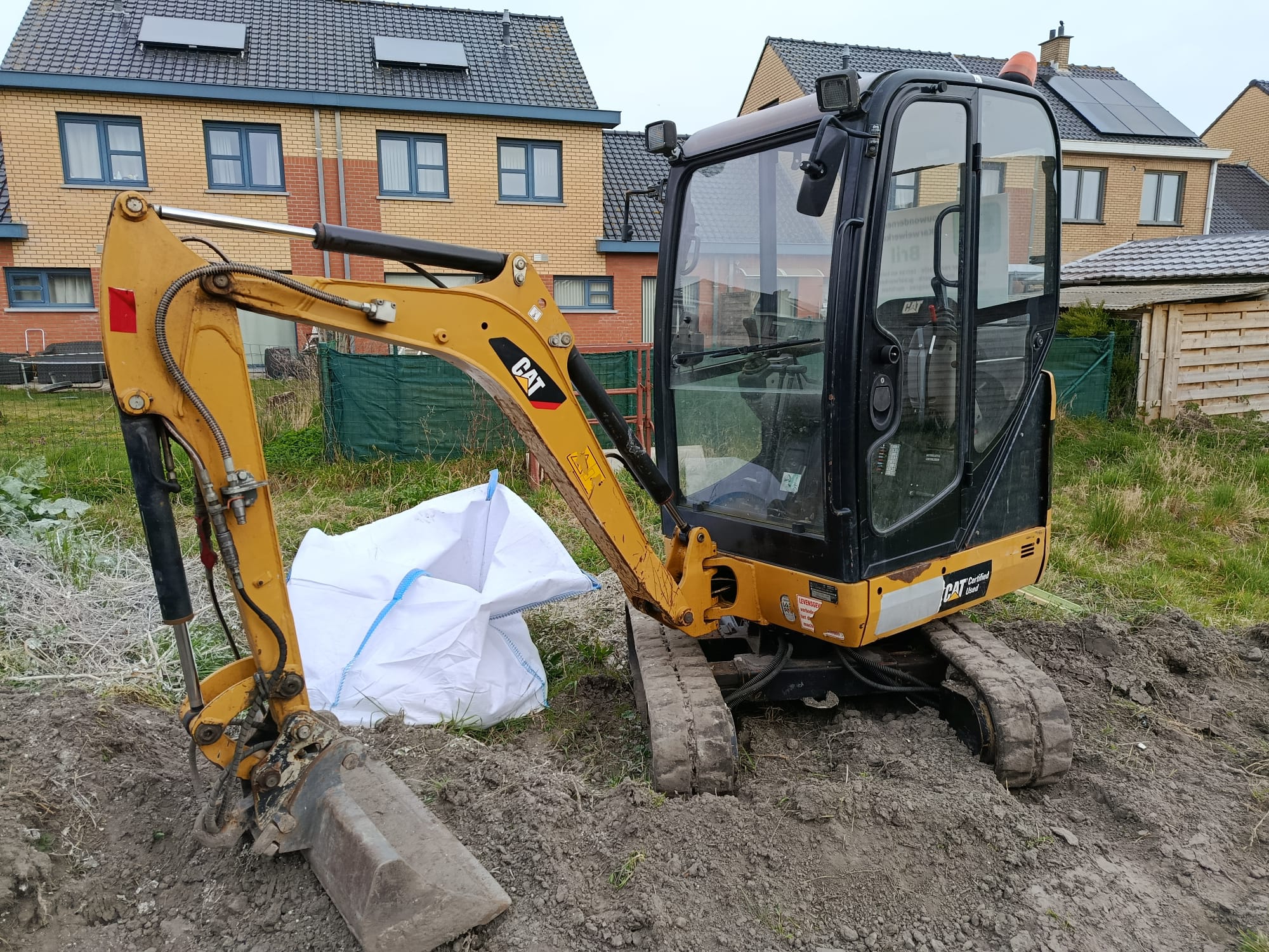Minigraver aan het werk tijdens de graaf- en grondwerken
